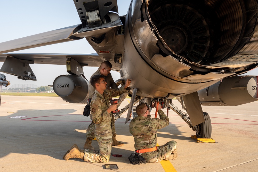 Aircraft technicians performing maintenance work inside a hangar