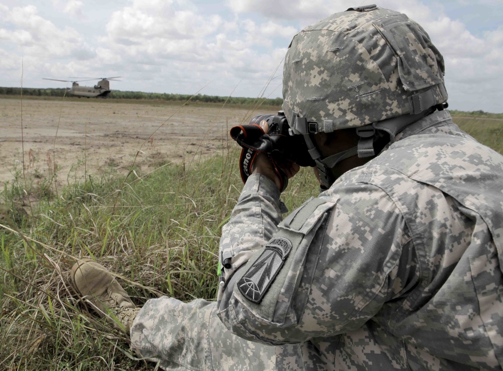 A combat camera soldier photographs a Chinook helicopter during operations