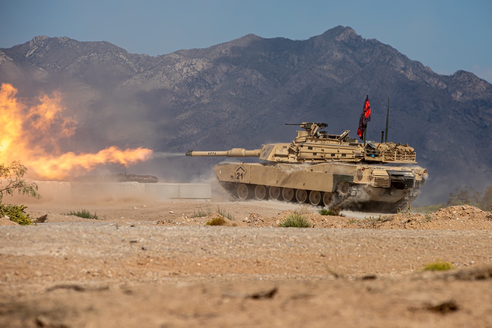 M1 Abrams tank firing its main gun at a target during gunnery training