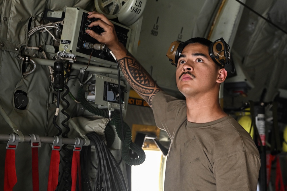 Crew chief adjusting lights on a C-130J Super Hercules during an inspection