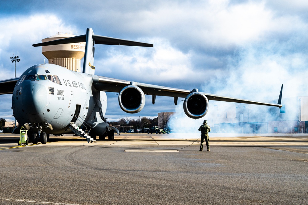 A crew chief performing a preflight inspection on a C-130 aircraft