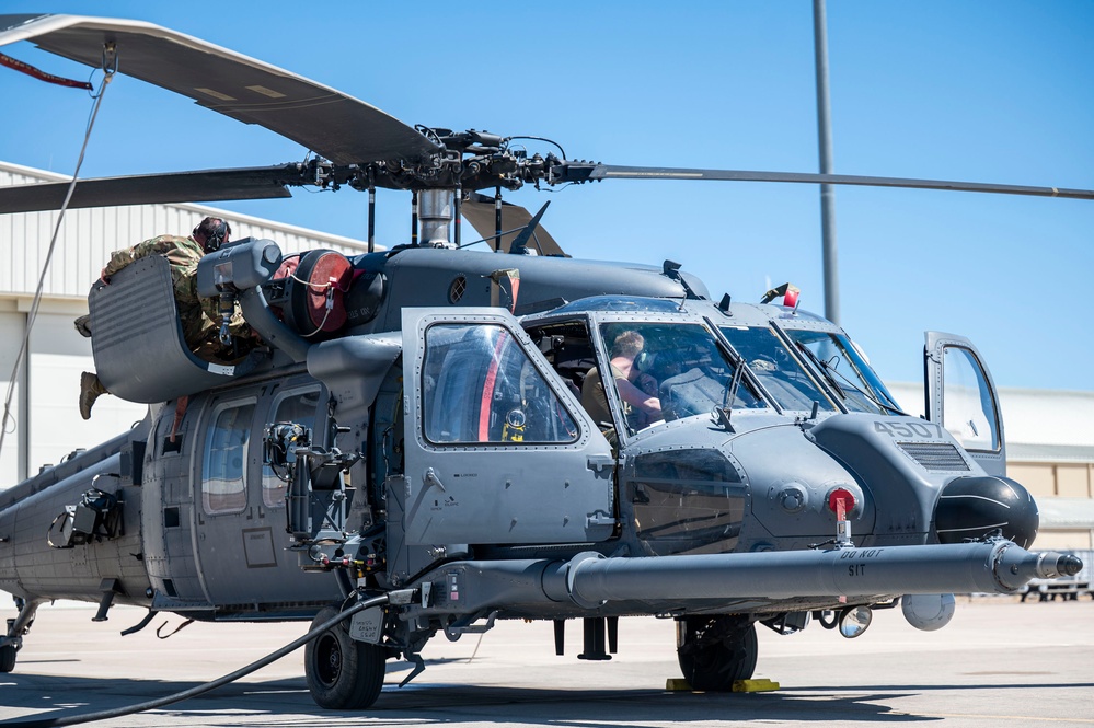 U.S. Air Force Airmen inspect an HH-60W Jolly Green II helicopter during routine servicing