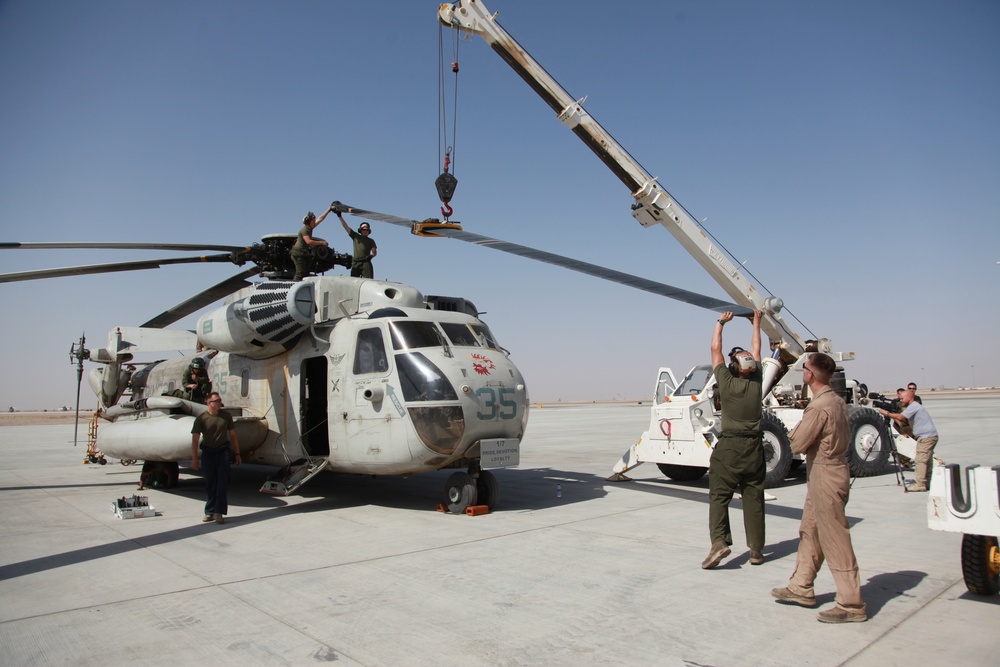 Marines disassemble the frame of a CH-53D Sea Stallion helicopter for decommissioning